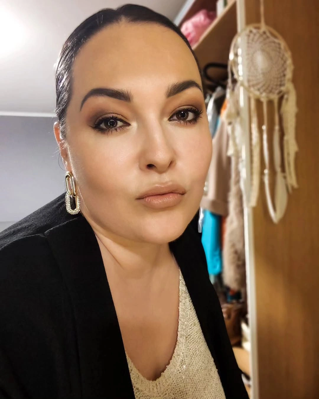 Sleek pulled-back hair with smooth front and gold earrings
