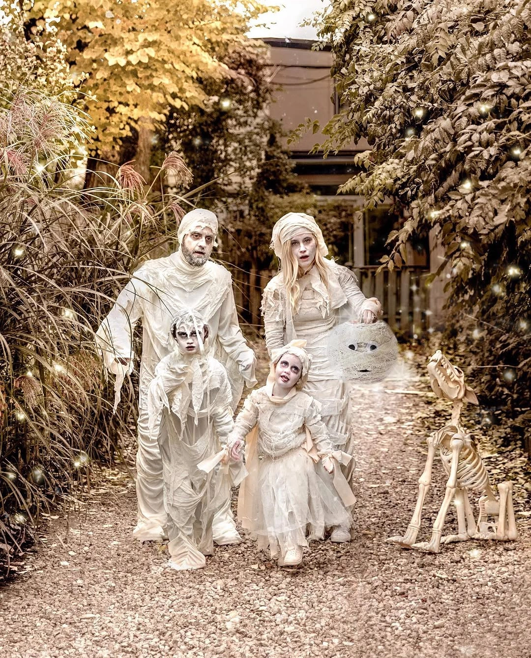 Family in white gray haunted bridal Halloween costumes in a wooded setting