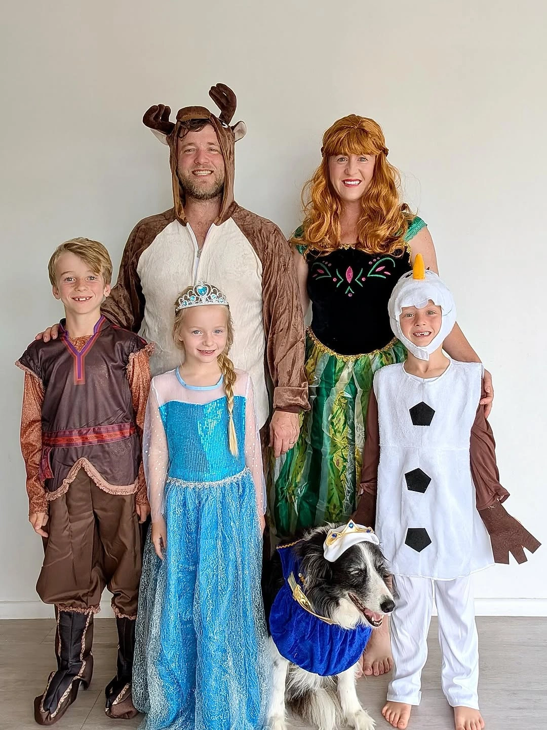 Family in blue white brown storybook Halloween costumes with a dog