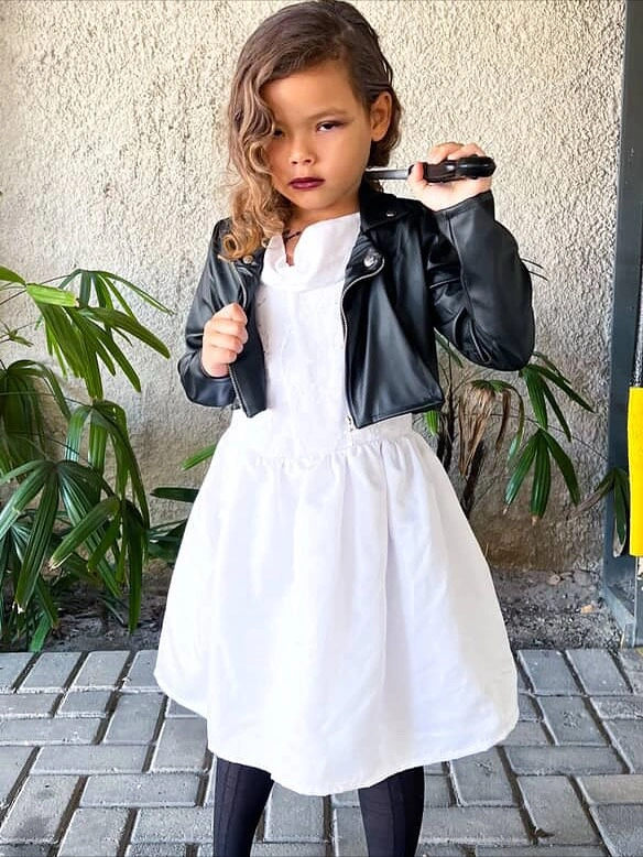Girl in white storybook dress with cropped black jacket dark tights and boots