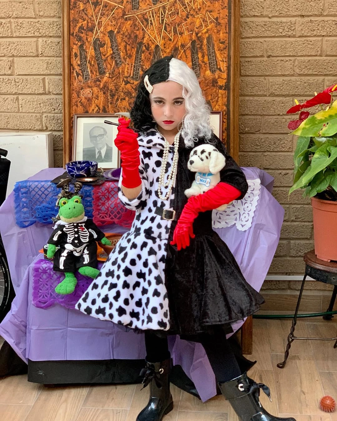 Girl in black white spotted costume with red gloves two-tone wig and black boots