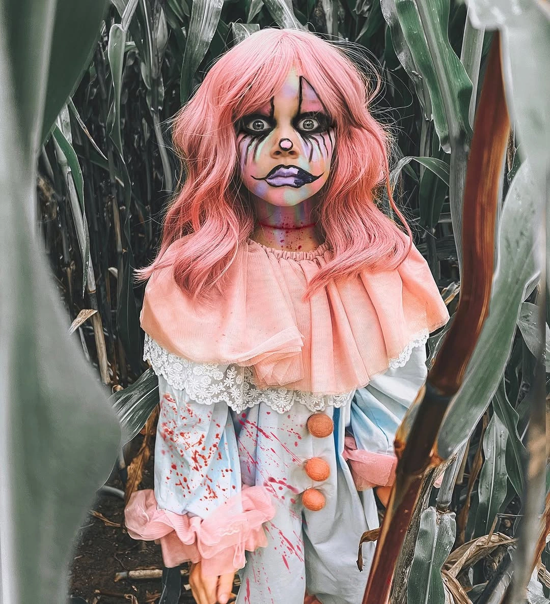 Girl in a pink layered doll Halloween costume with large pink wig