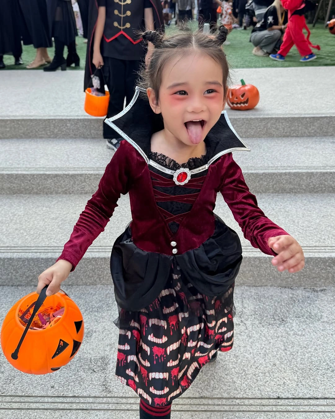 Girl in burgundy velvet and black high-collar vampire-inspired Halloween costume