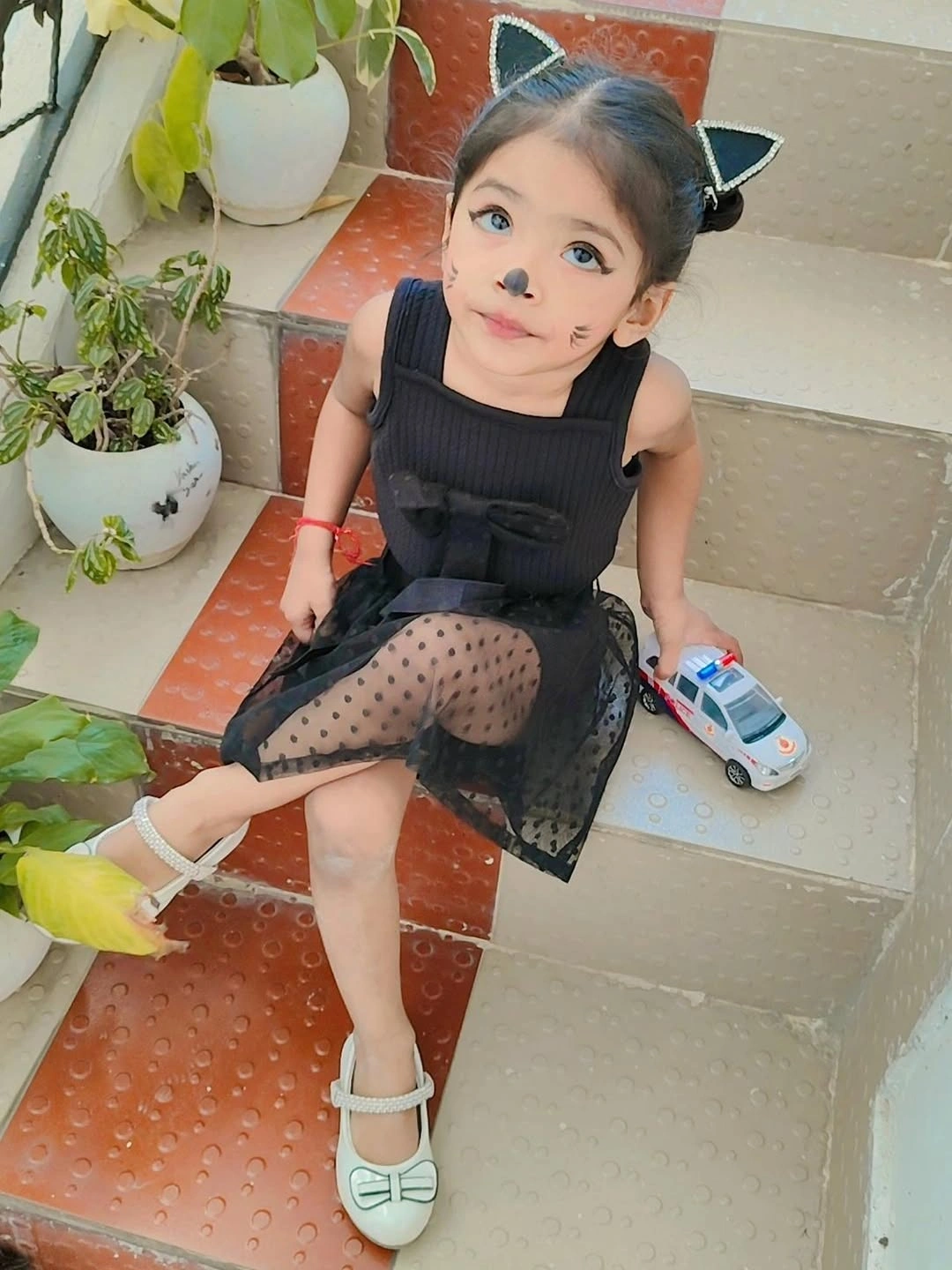 Girl in black cat costume with pointed ears and dotted sheer skirt