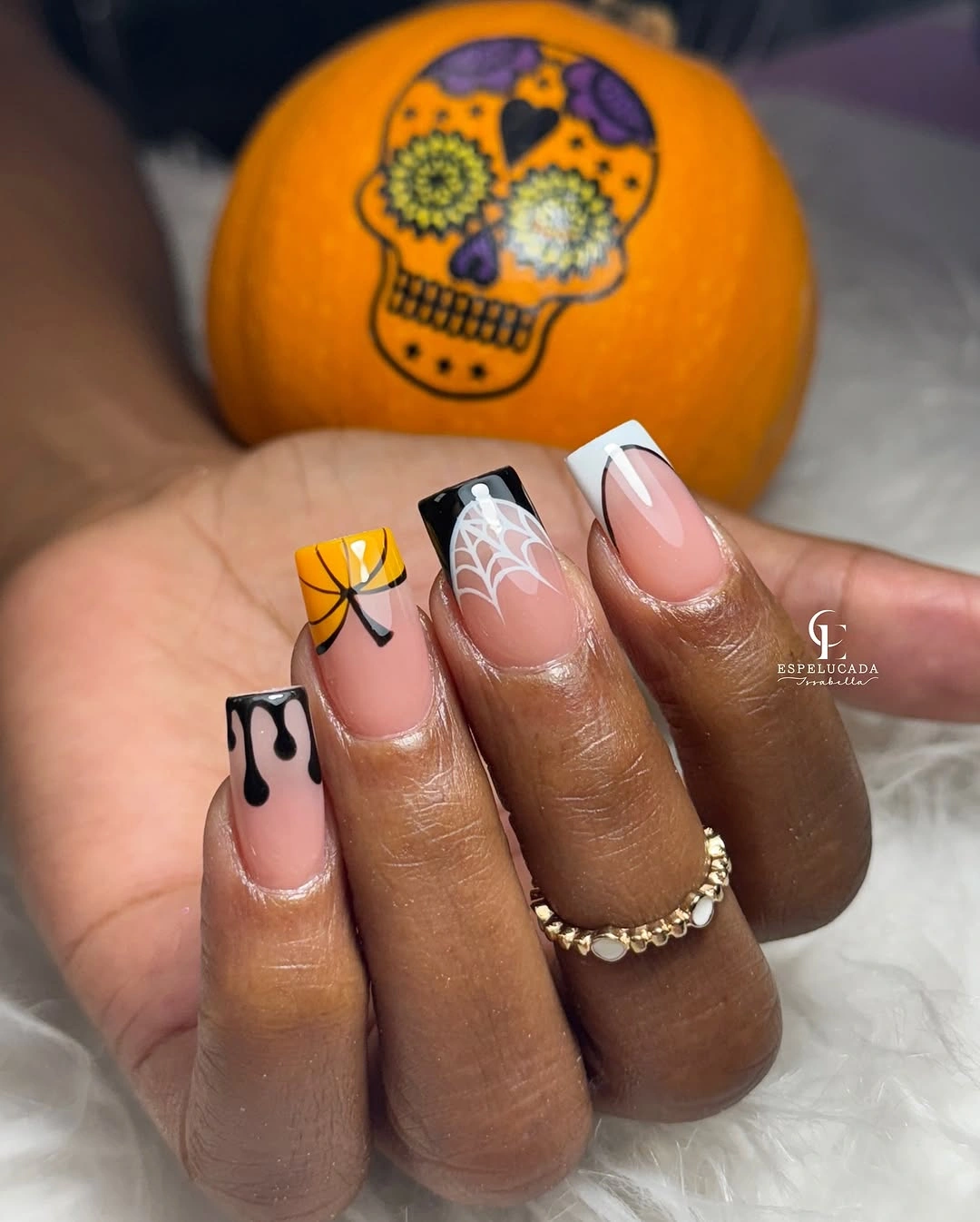 Long nude square nails with black drips web orange pumpkin and bow accents