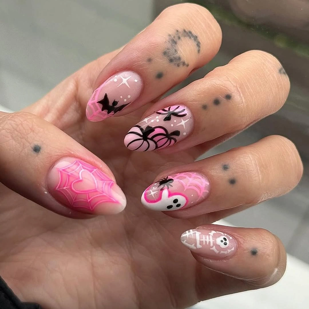Short pink oval nails with black spiders web lines dots and tiny face art