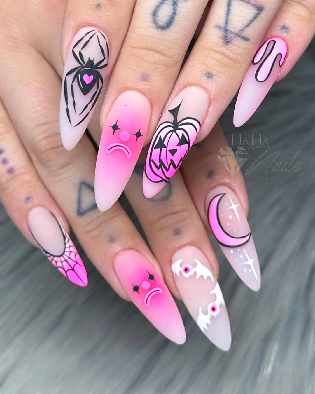 Long pointed pink nails with black webs orange pumpkins white ghosts and graphic outlines