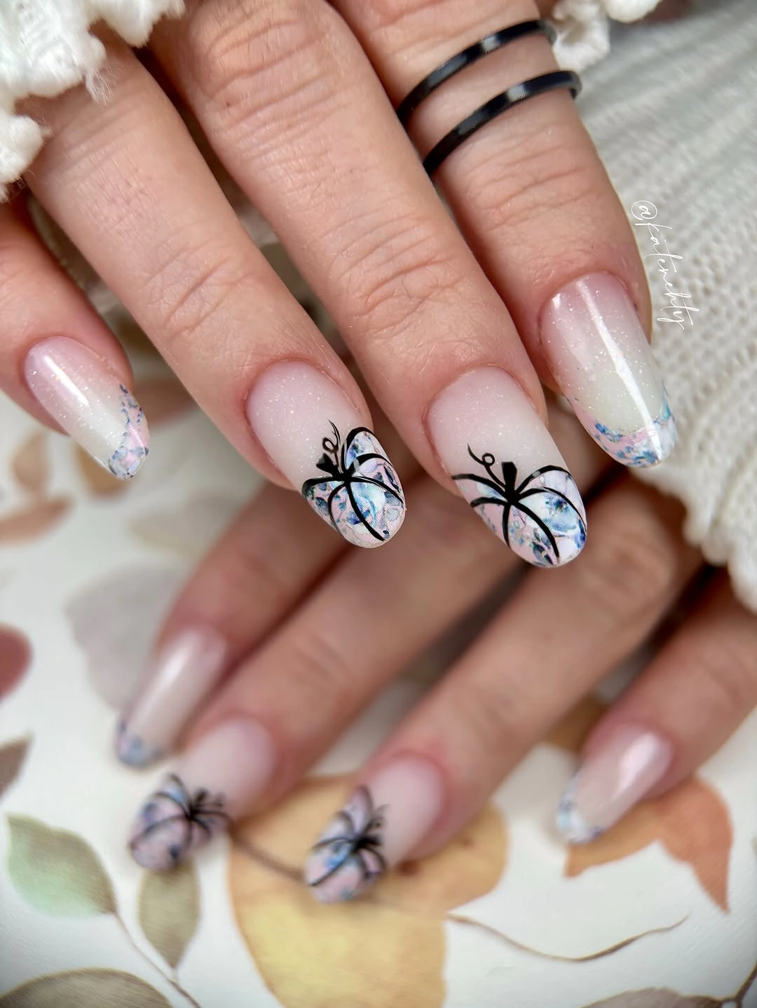 Pearly nude almond nails with delicate black spiders web lines and tiny ghost