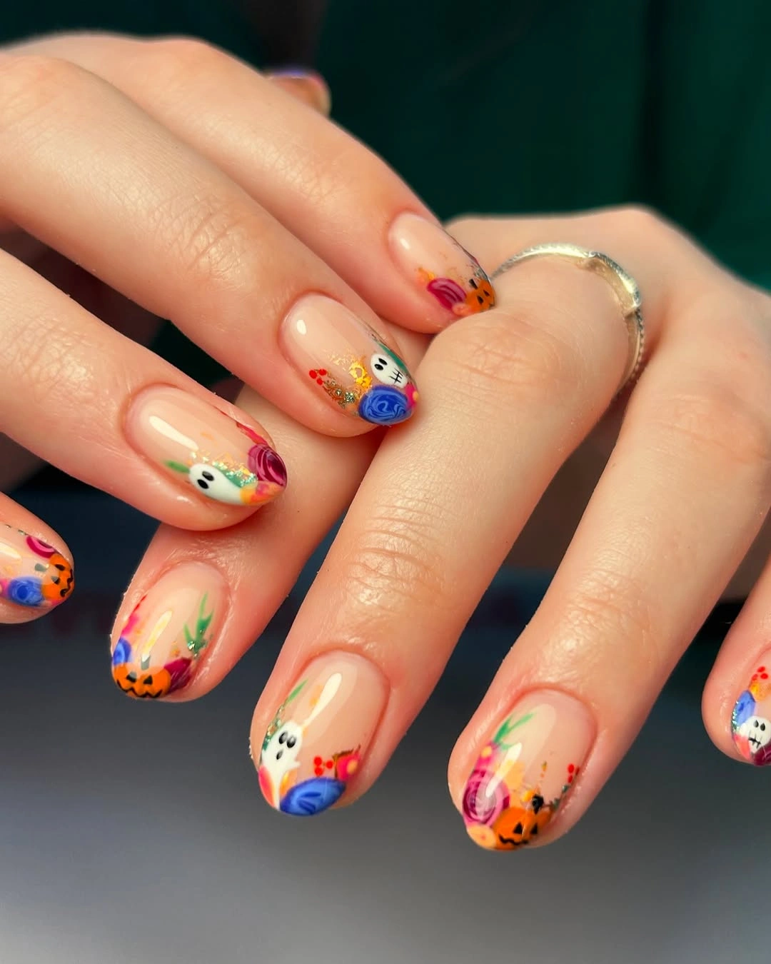 Short nude nails with colorful tiny pumpkin and Halloween face tip art