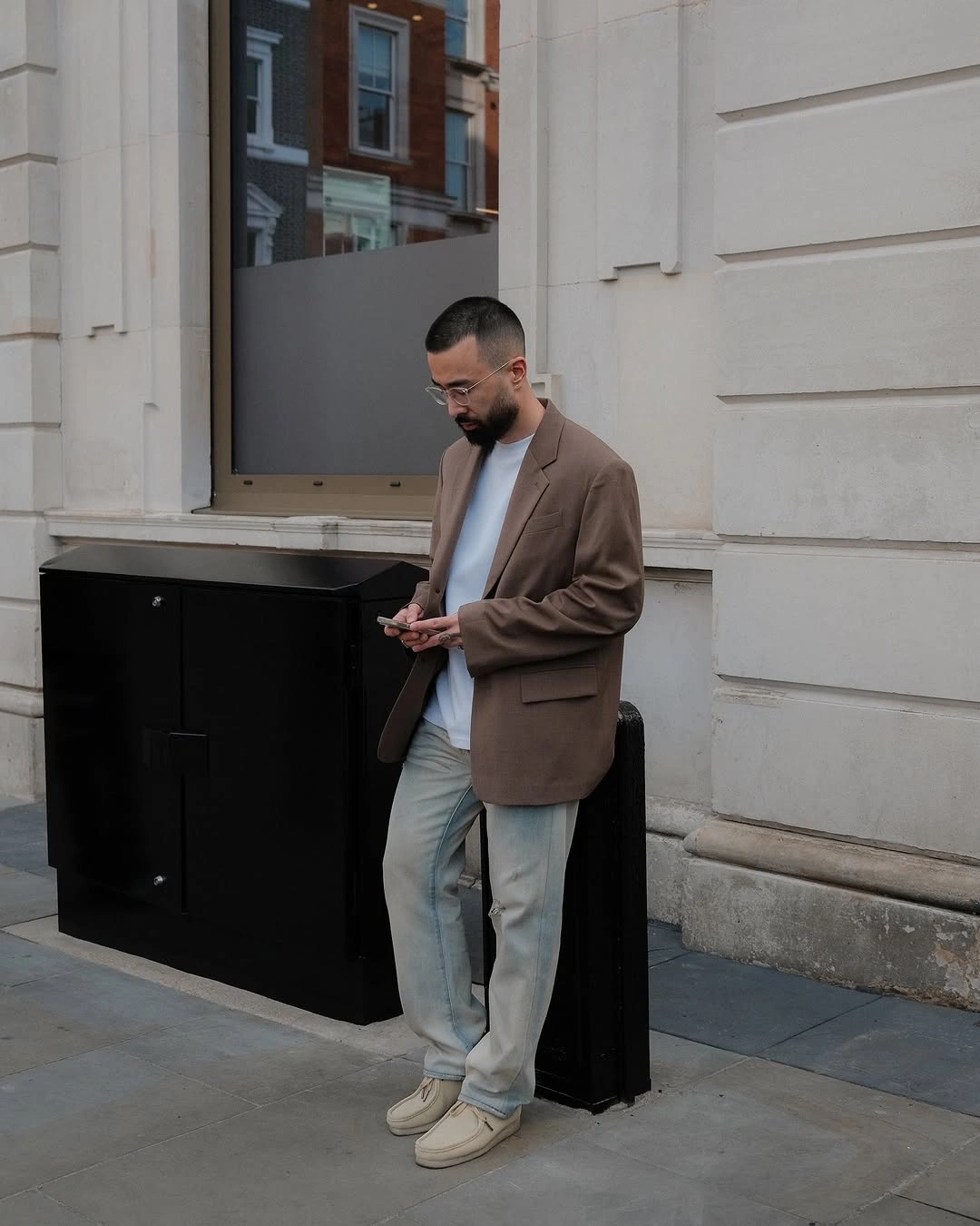 Relaxed brown blazer with pale gray wide trousers and light sneakers