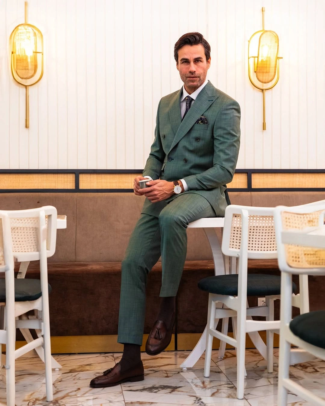 Deep green suit with dark top black ankle boots and seated pose