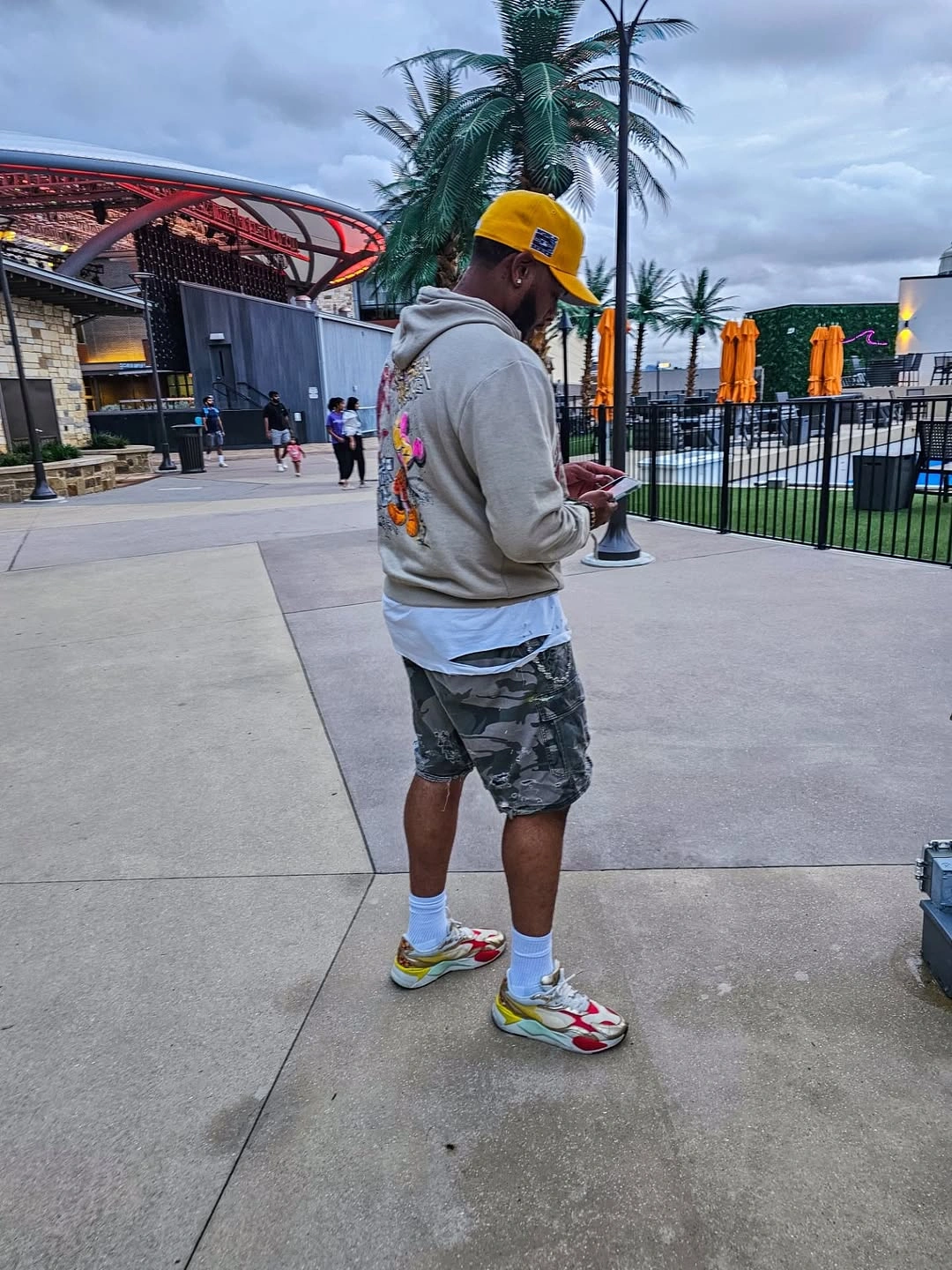 Gray hoodie printed shorts yellow cap and colorful running shoes
