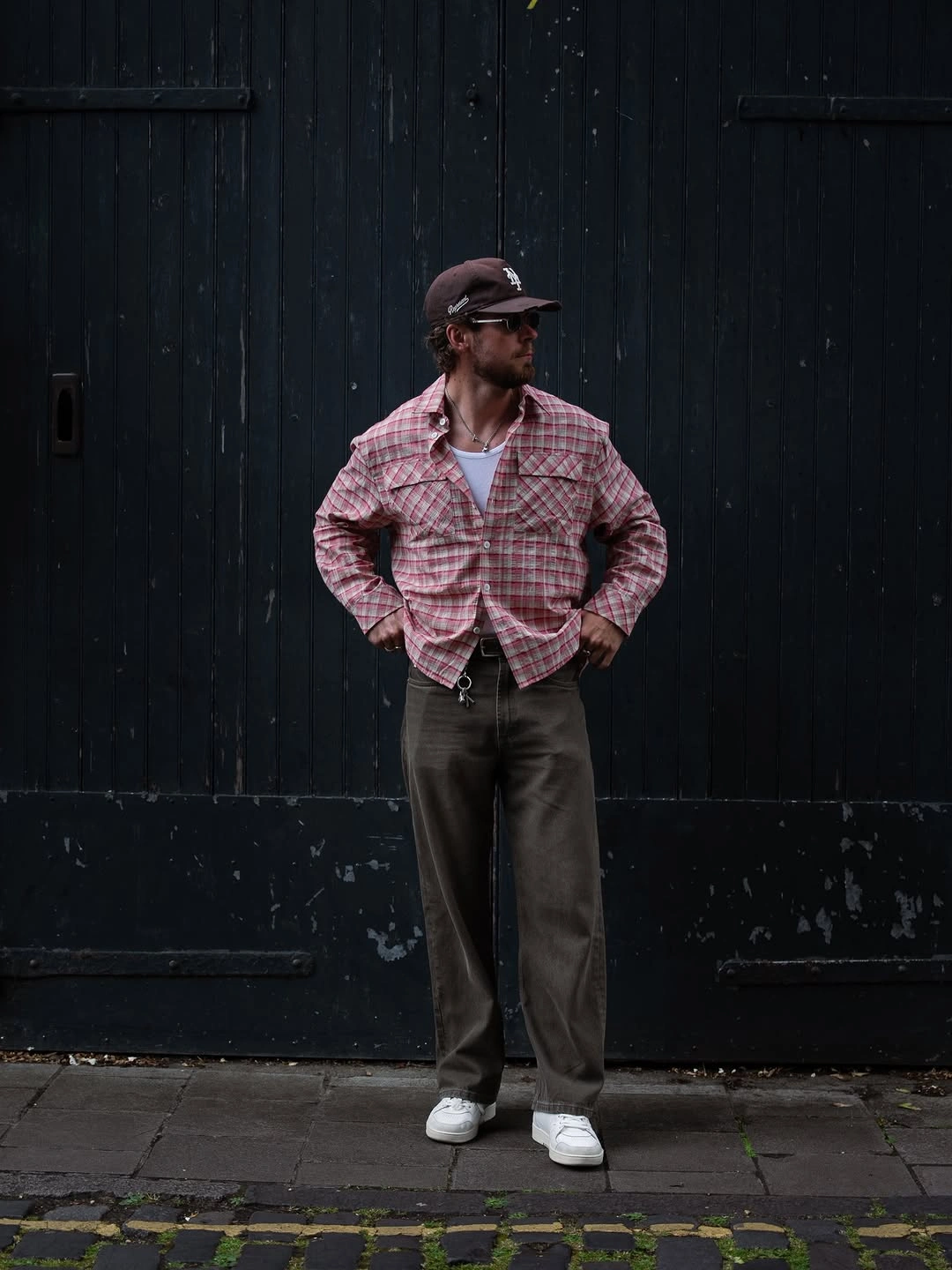 Red checked shirt with dark loose trousers and white sneakers