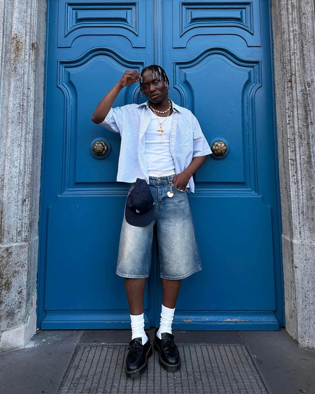 White graphic tee with denim shorts black loafers and shoulder bag