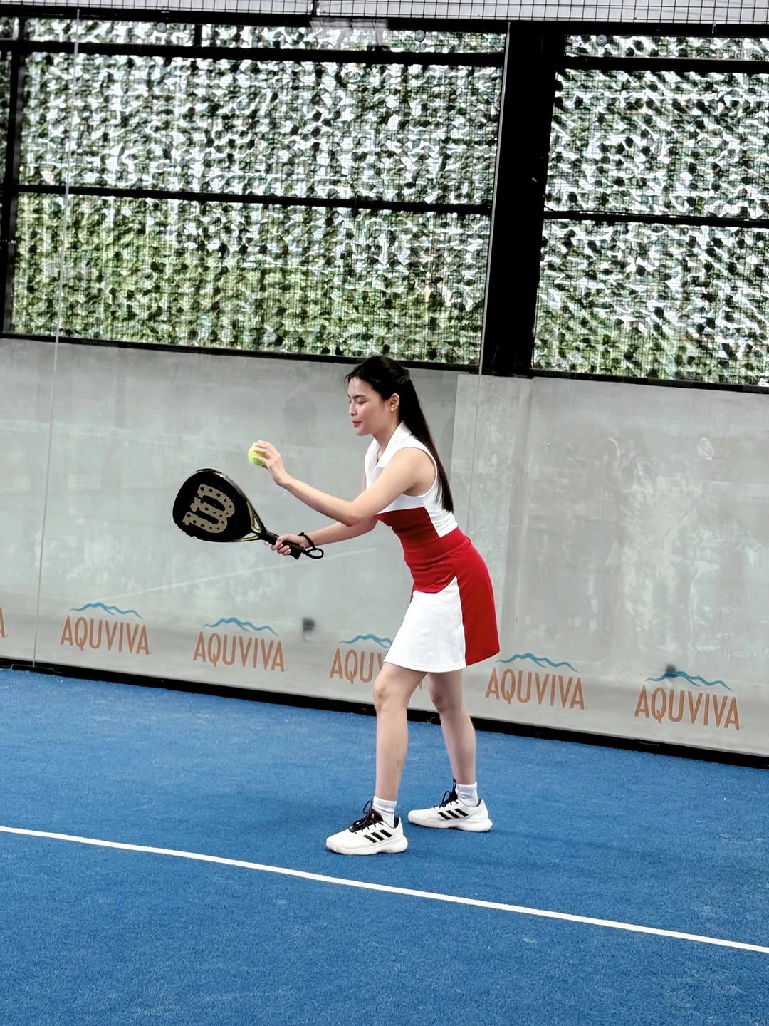 White padel tank with bright red pleated skirt and racket