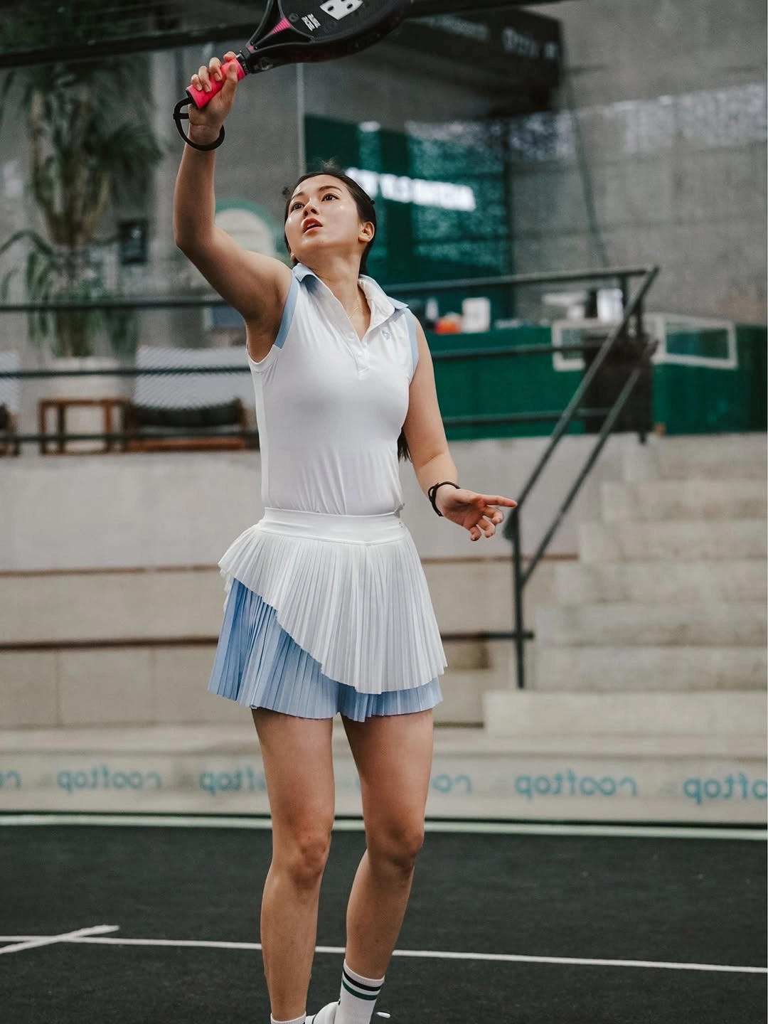 White polo with pale blue pleated skirt and striped socks