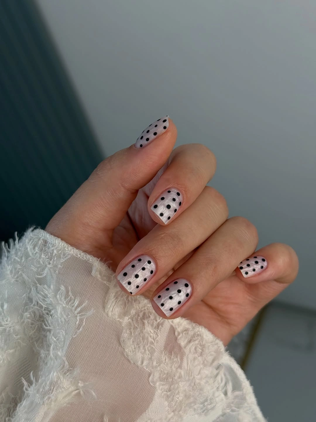 Short nude square nails with black dotted white tips and one reversed black white dotted accent
