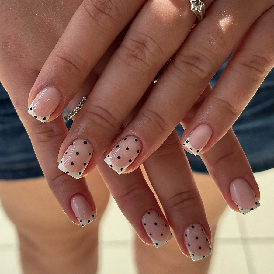 Long square pink nails with white black dotted tips and fine dark outline details