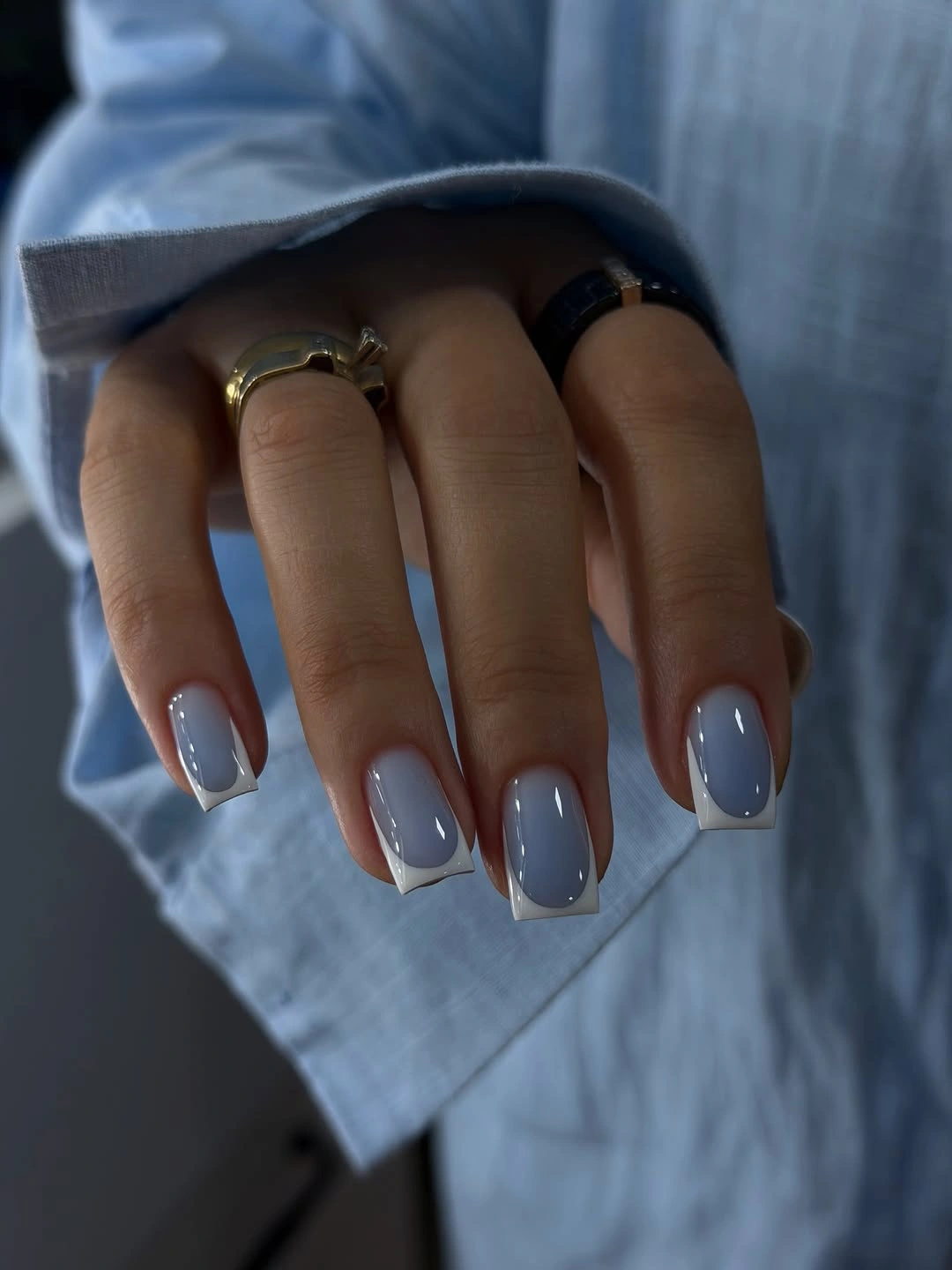 Short rounded-square nails with blue-gray polish and pale edges