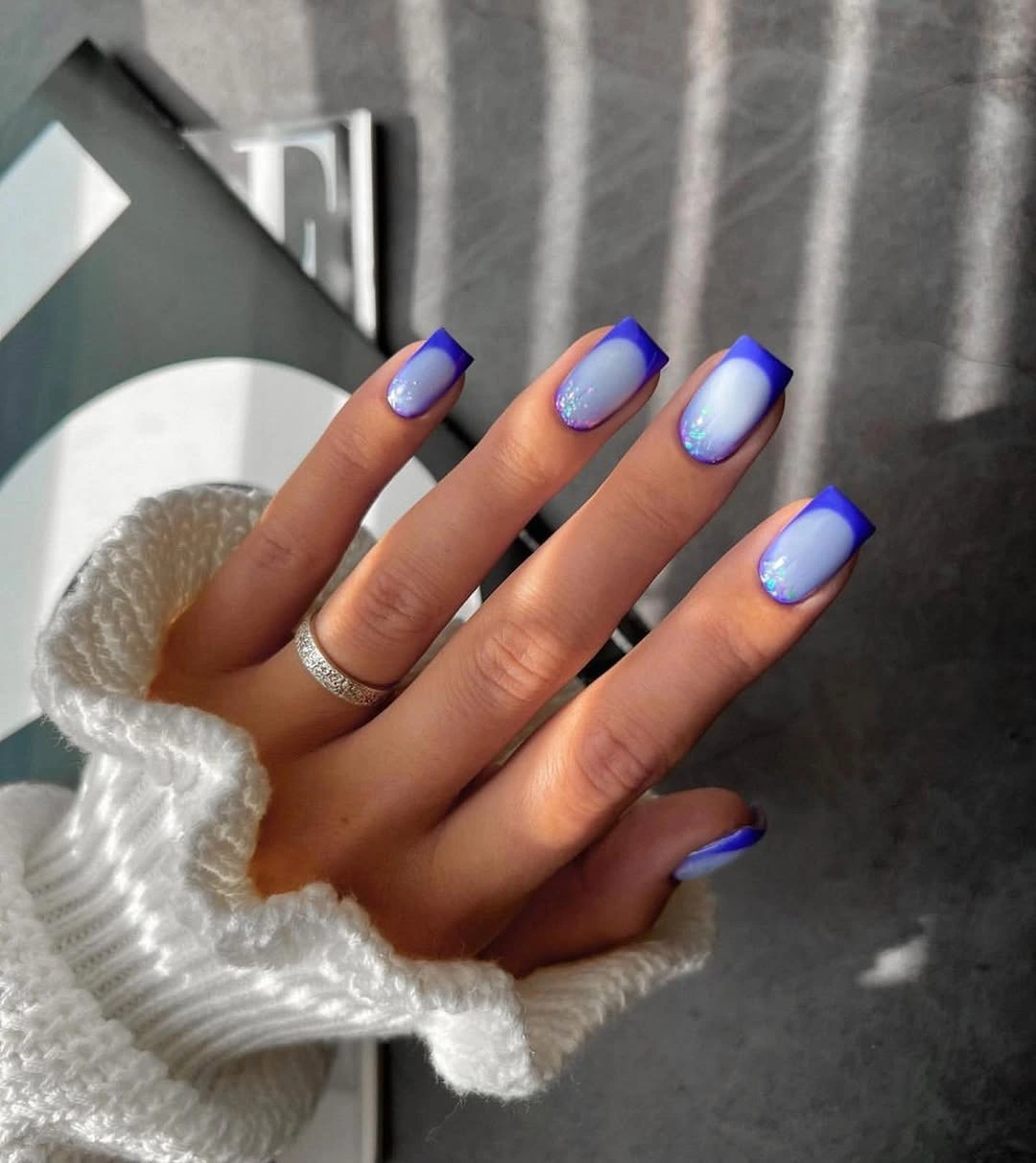 Medium squared nails with cobalt tips and pale blue sparkle