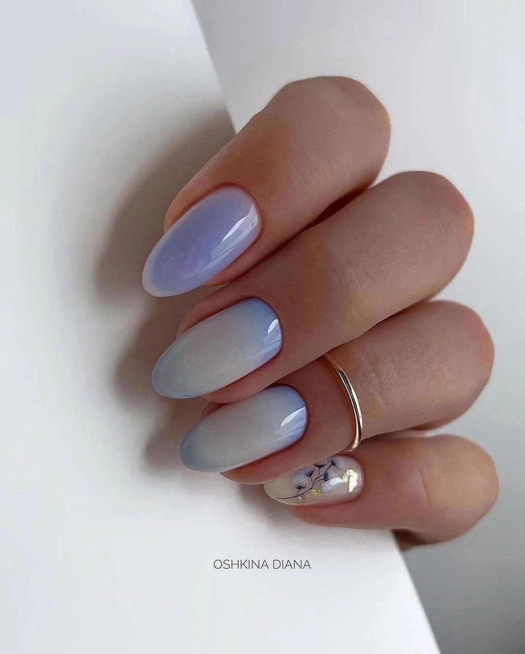 Almond nails with soft blue-white gradient and floral accent