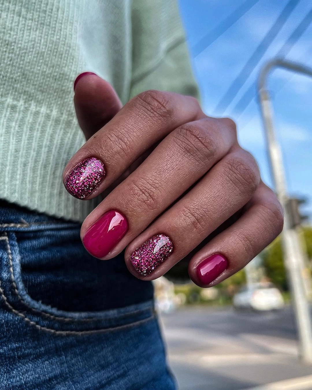 Very short pink nails with dense pink glitter accents
