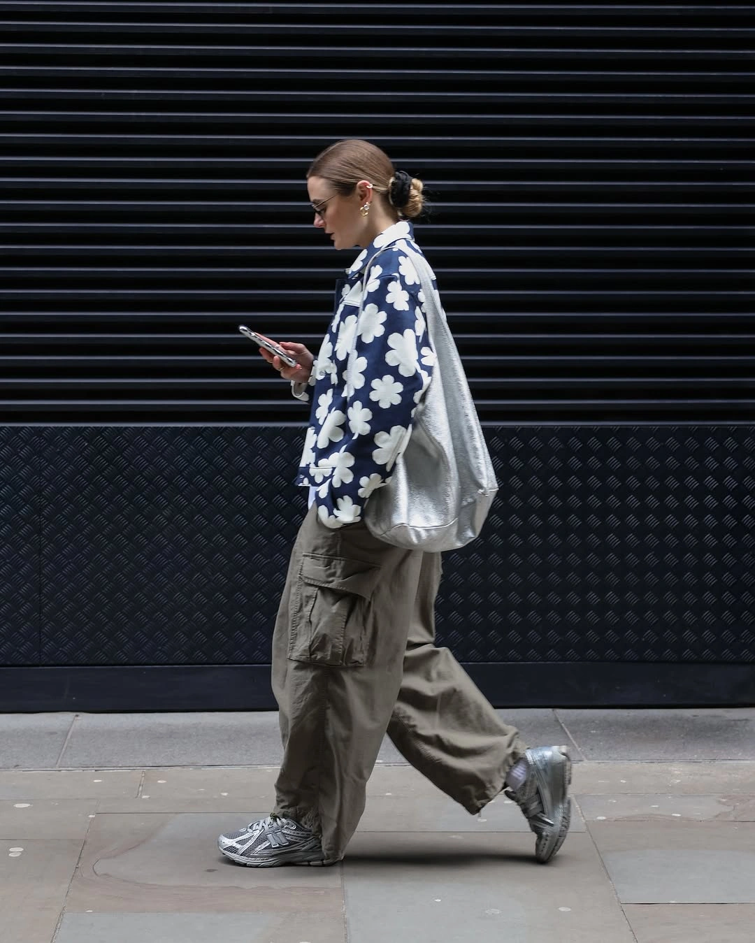 Navy floral jacket with olive cargo pants, gray silver sneakers, and metallic shoulder bag