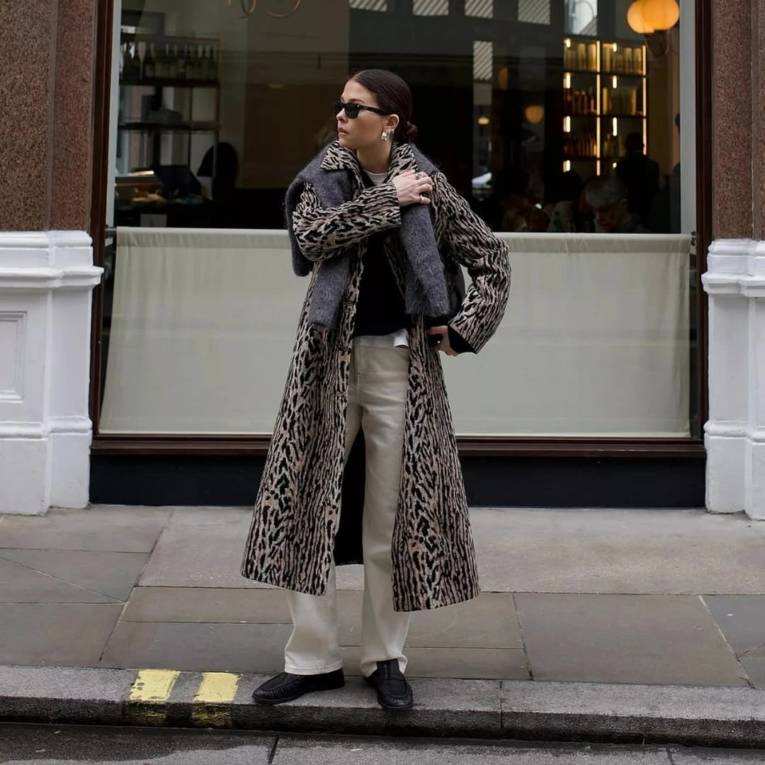 Animal-pattern coat with pale trousers and dark accessories