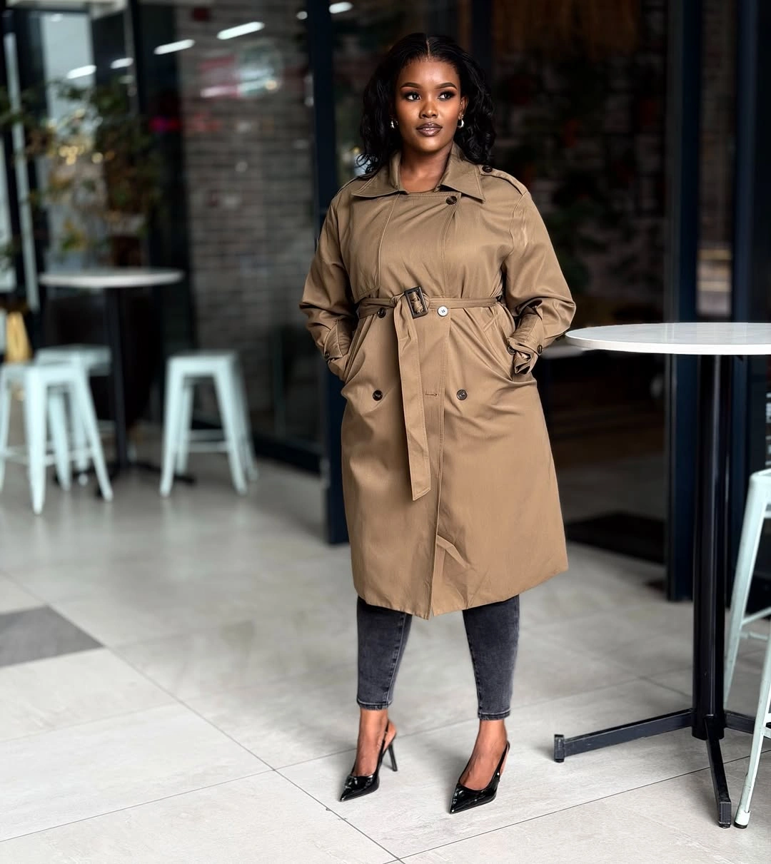 Tan belted trench coat with cropped gray jeans