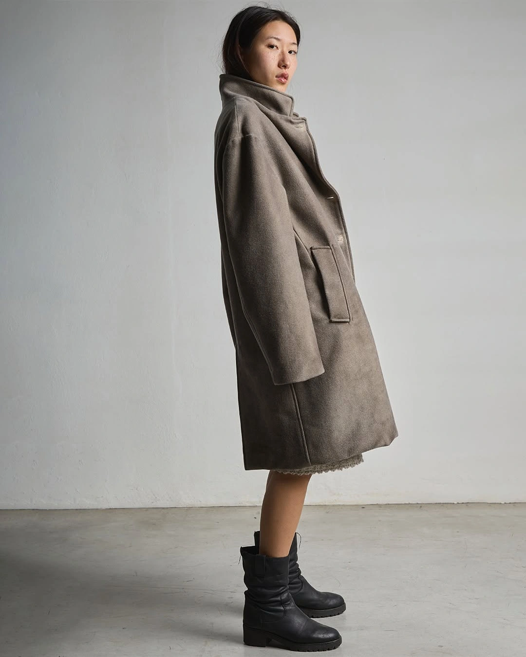 Taupe-gray mid-length coat with high collar and black boots