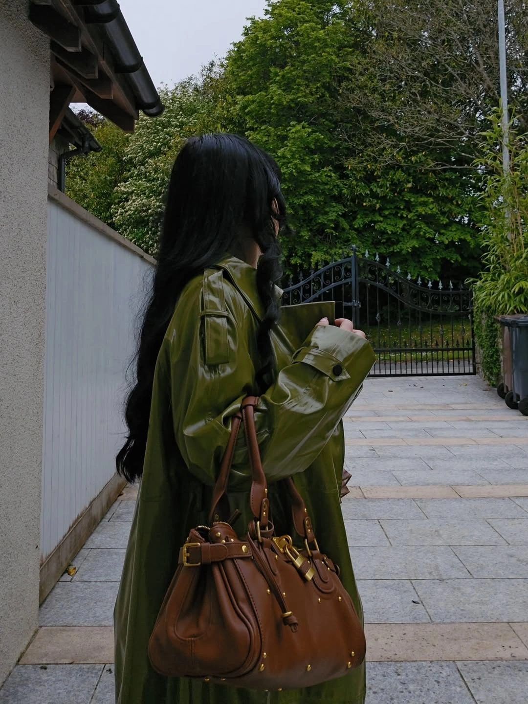 Glossy olive long coat with large brown structured handbag