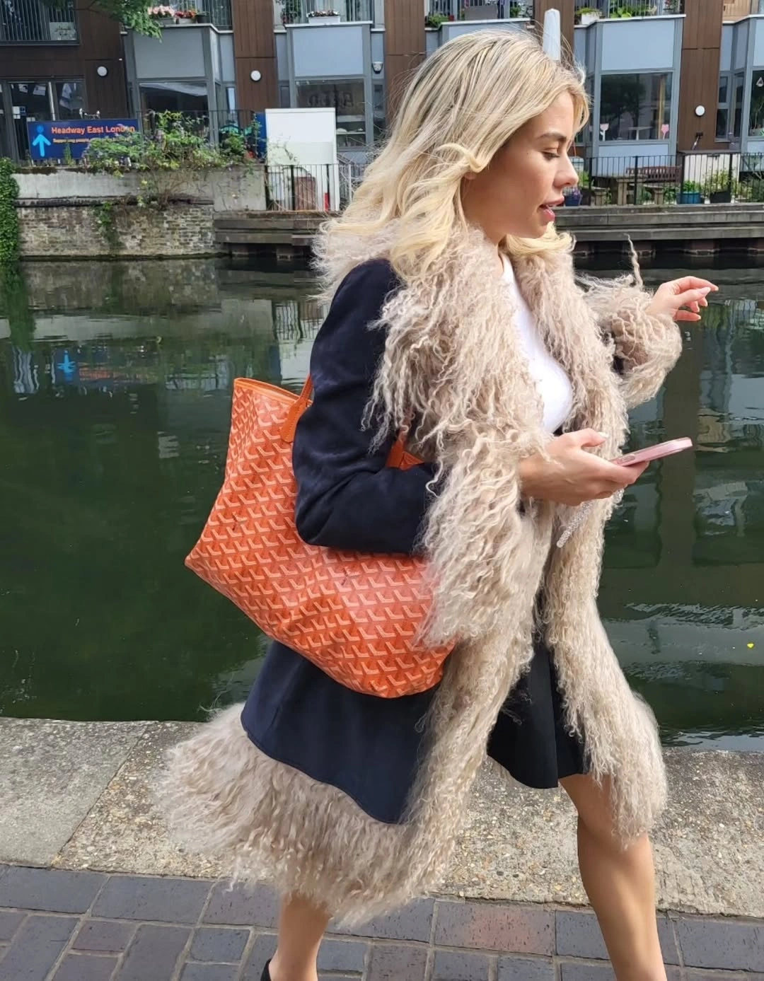 Cream shaggy layer over dark jacket with orange tote