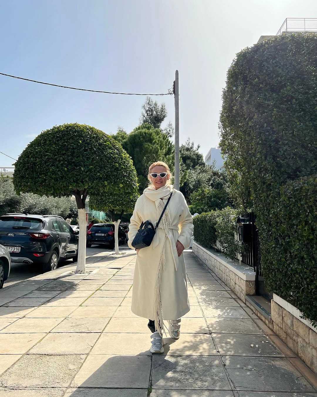 Cream wrap coat with pale scarf and patterned trousers