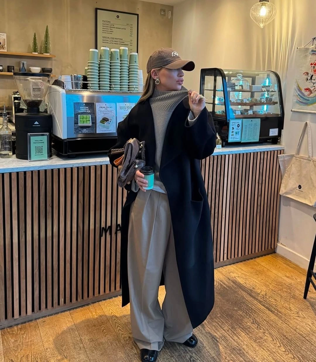 Long dark open coat with gray turtleneck and pale trousers