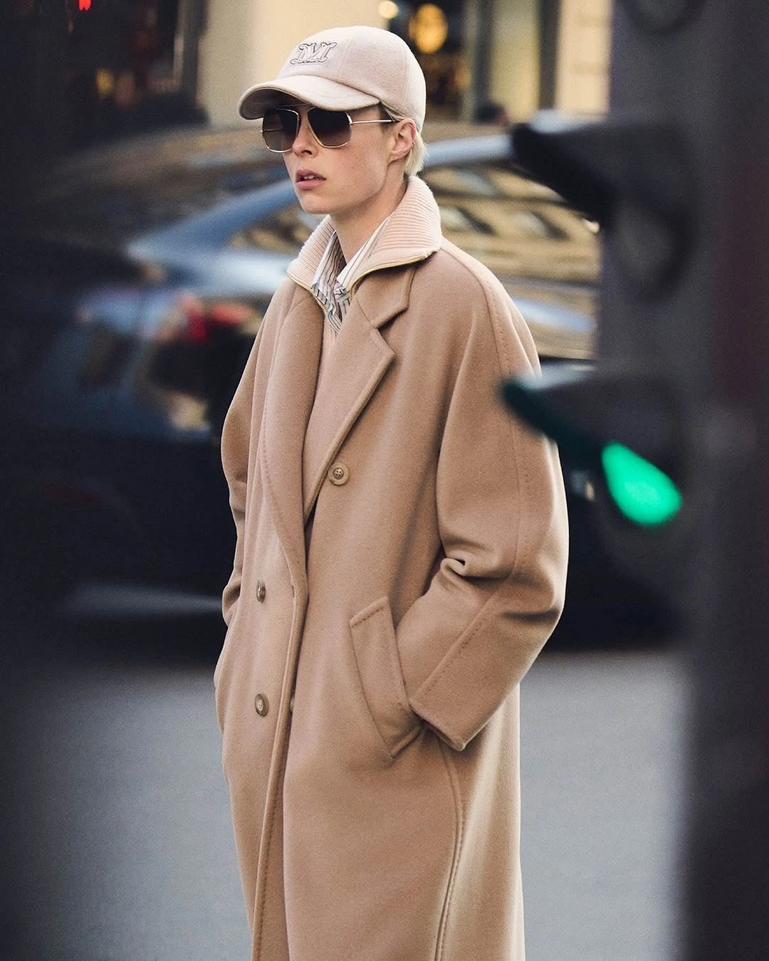 Long camel coat with pale cap and sunglasses