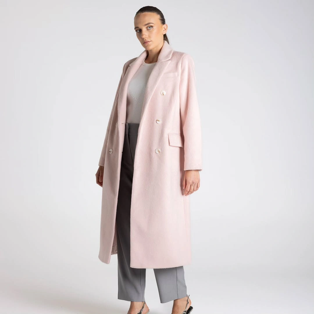 Pale pink double-breasted coat with gray trousers