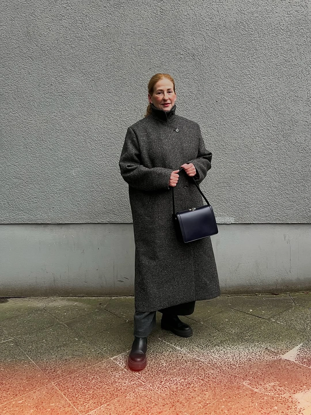 Charcoal textured long coat with black boots and handbag