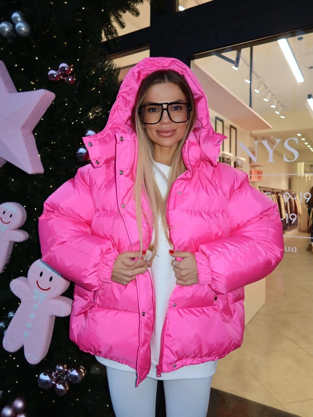Hot pink hooded puffer over white layers and pants
