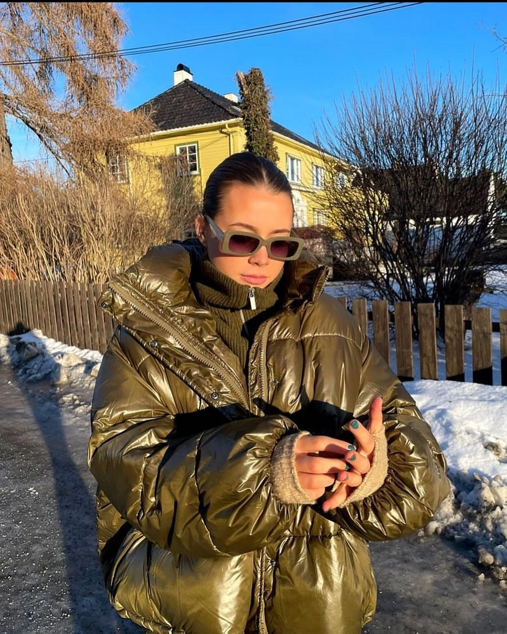 Glossy olive cropped puffer with black layer and sunglasses