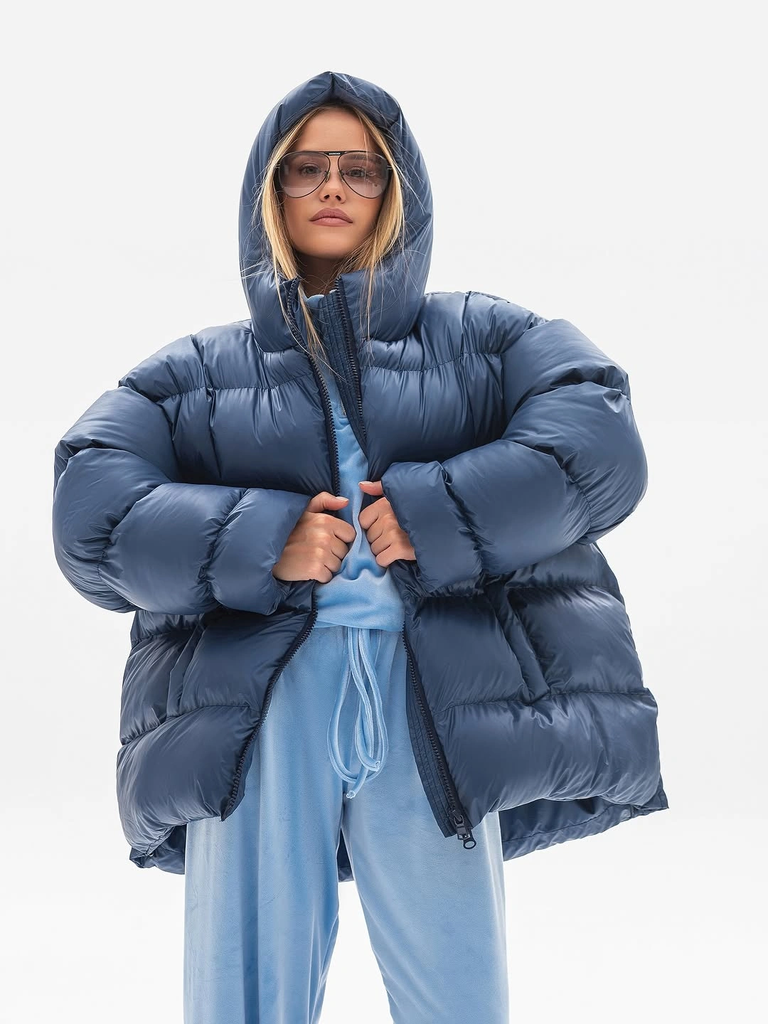 Oversized blue hooded puffer over pale blue sweatsuit