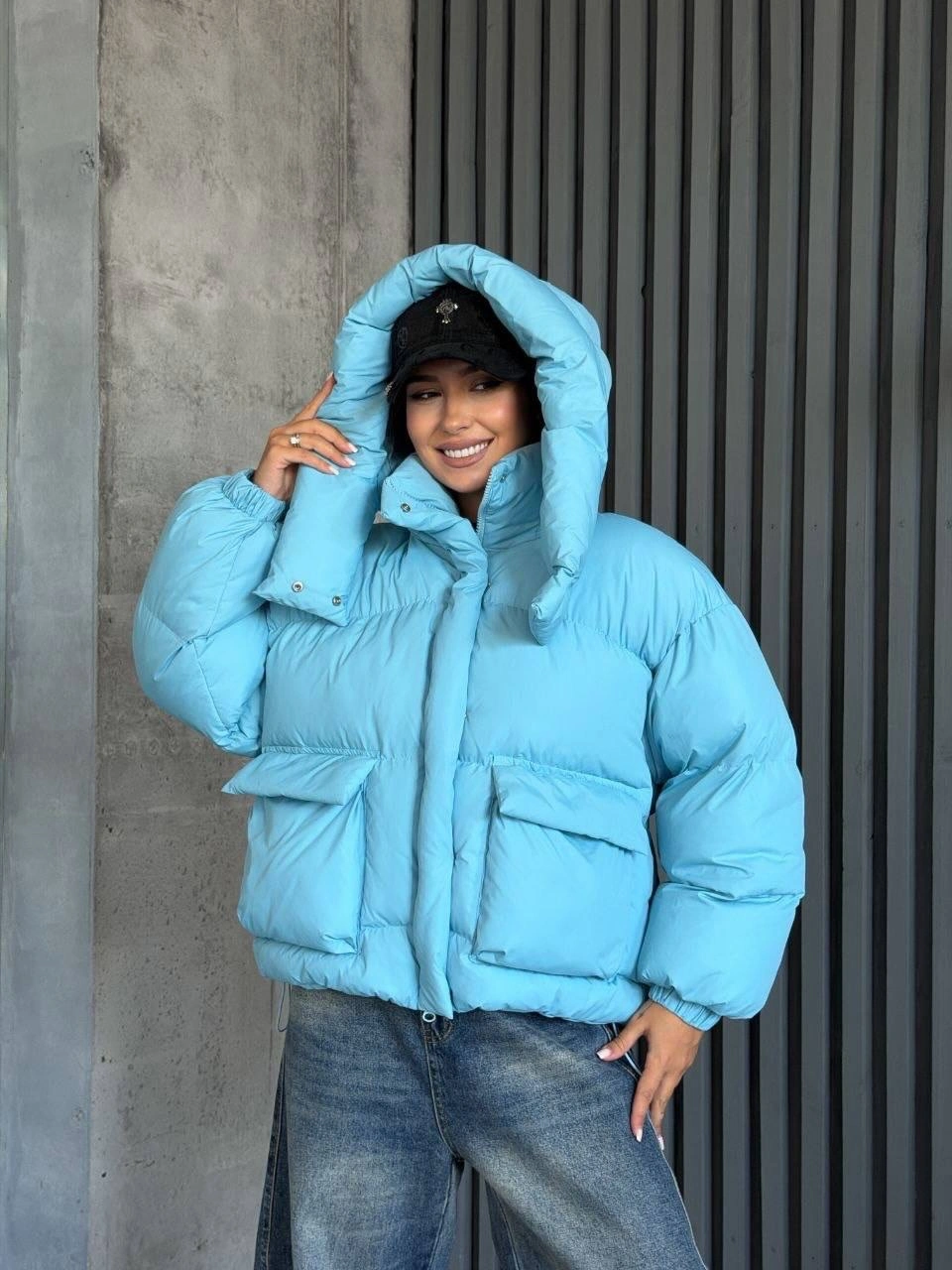 Sky-blue hooded puffer with black cap and wide jeans