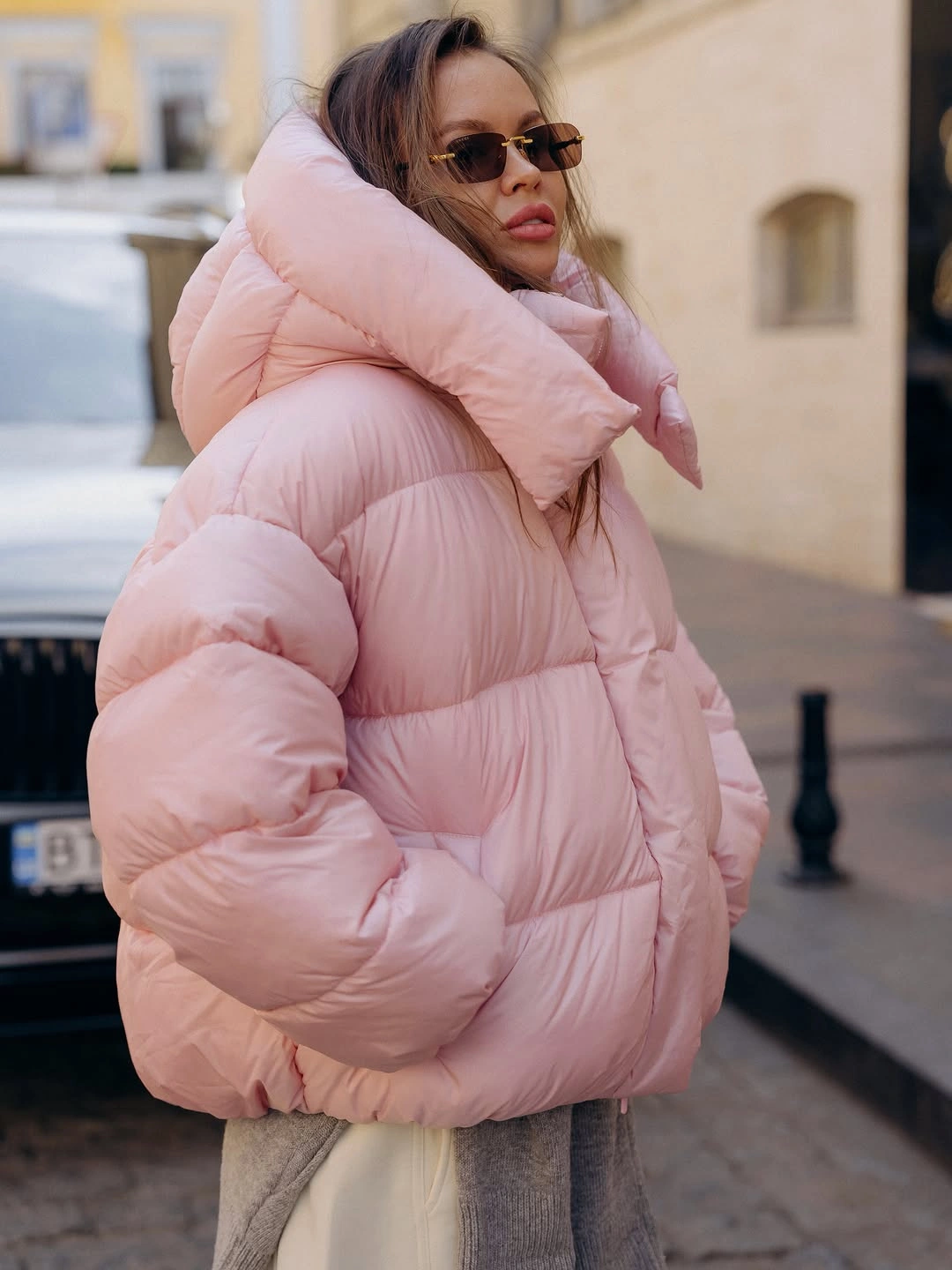 Pale pink oversized puffer with sunglasses and gray lower layer