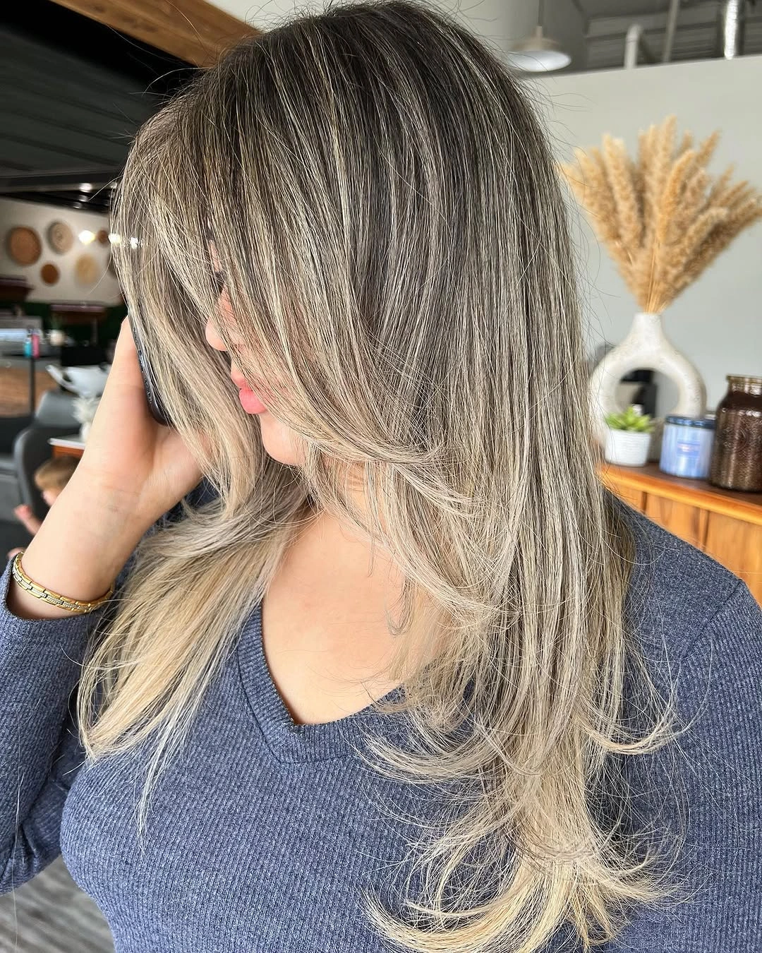 Long gray-blonde layered hair with open curtain-like fringe