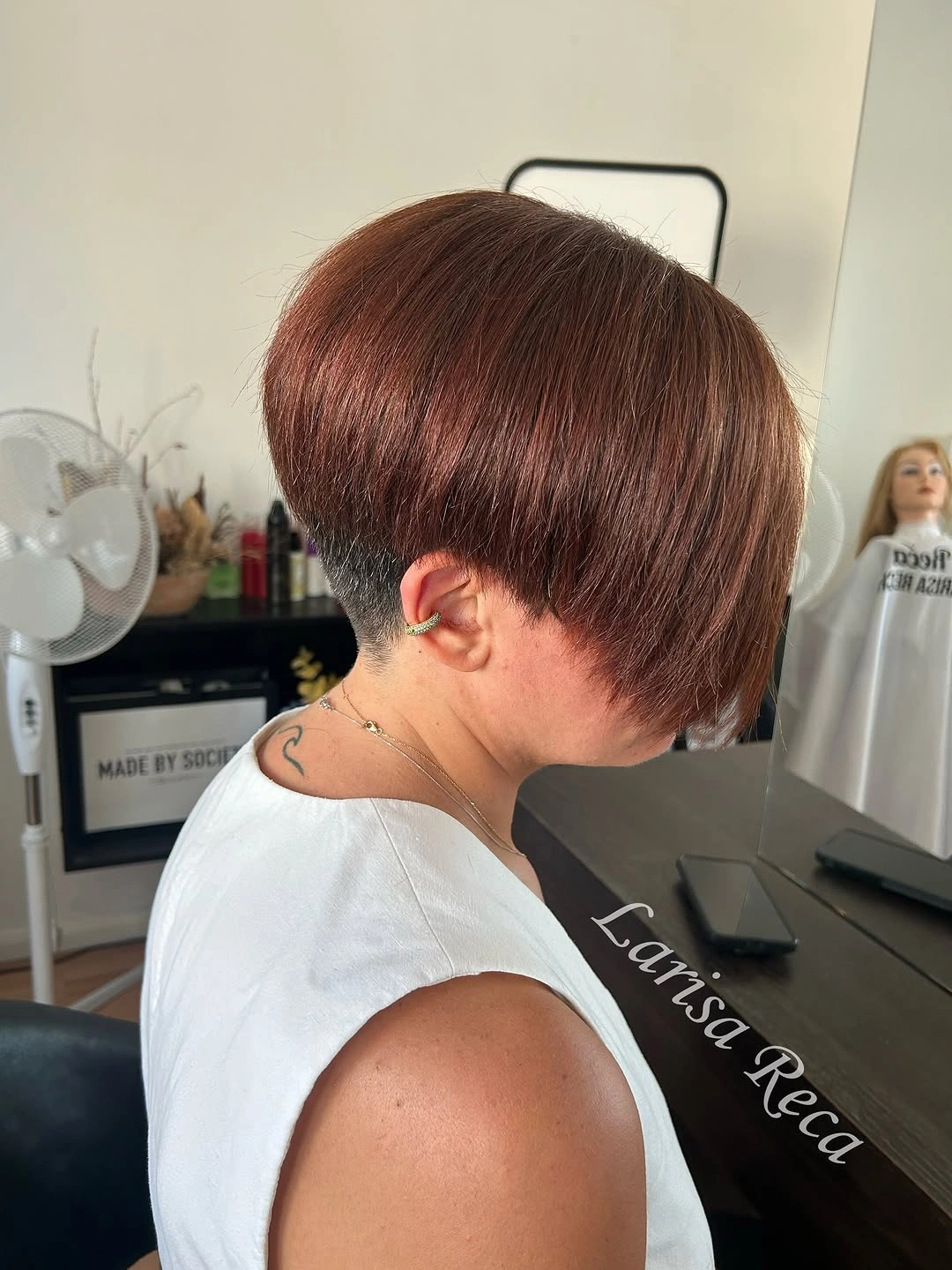 Short auburn rounded crop with compact nape and side profile