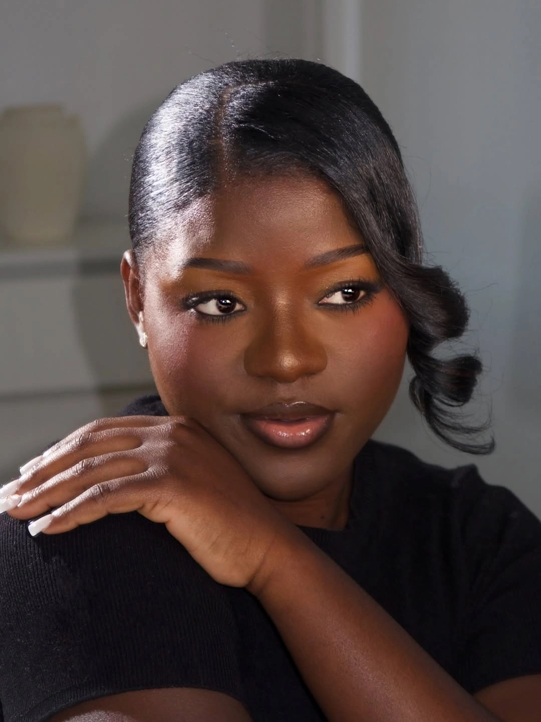 Glossy side part with sculpted curl over one shoulder