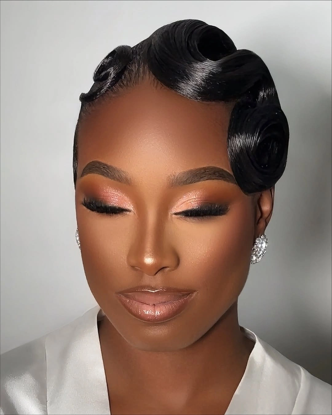 Sculpted glossy black waves with curled side details