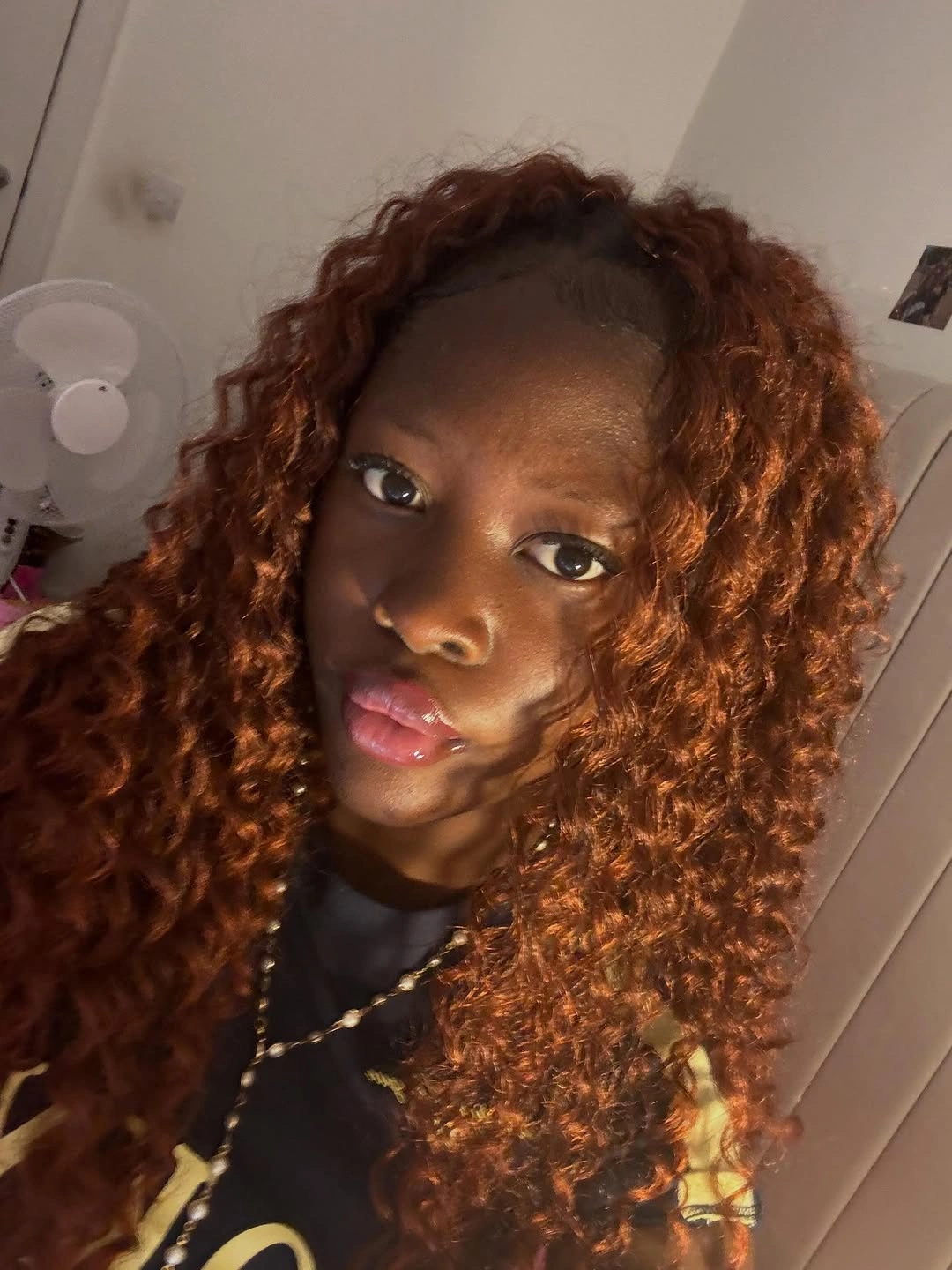 Long copper curls falling around the shoulders indoors