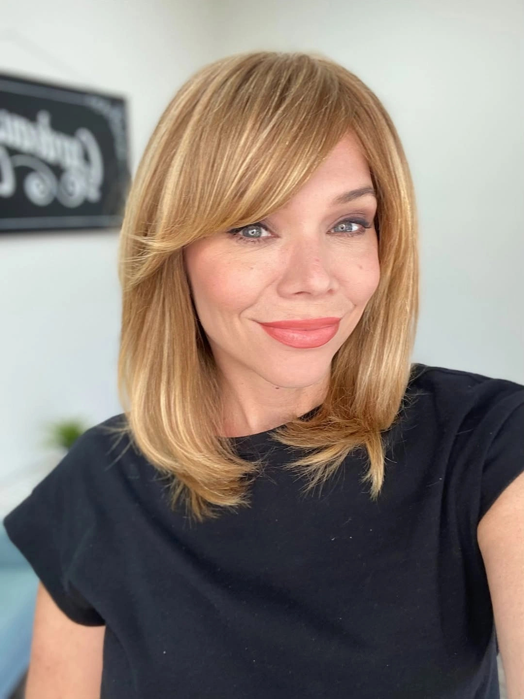 Blonde shoulder-length hair with side-swept bangs and smooth ends