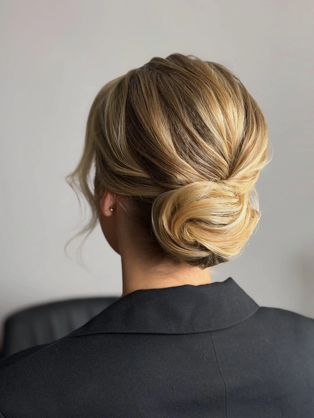 Back view of blonde low bun with swept sections