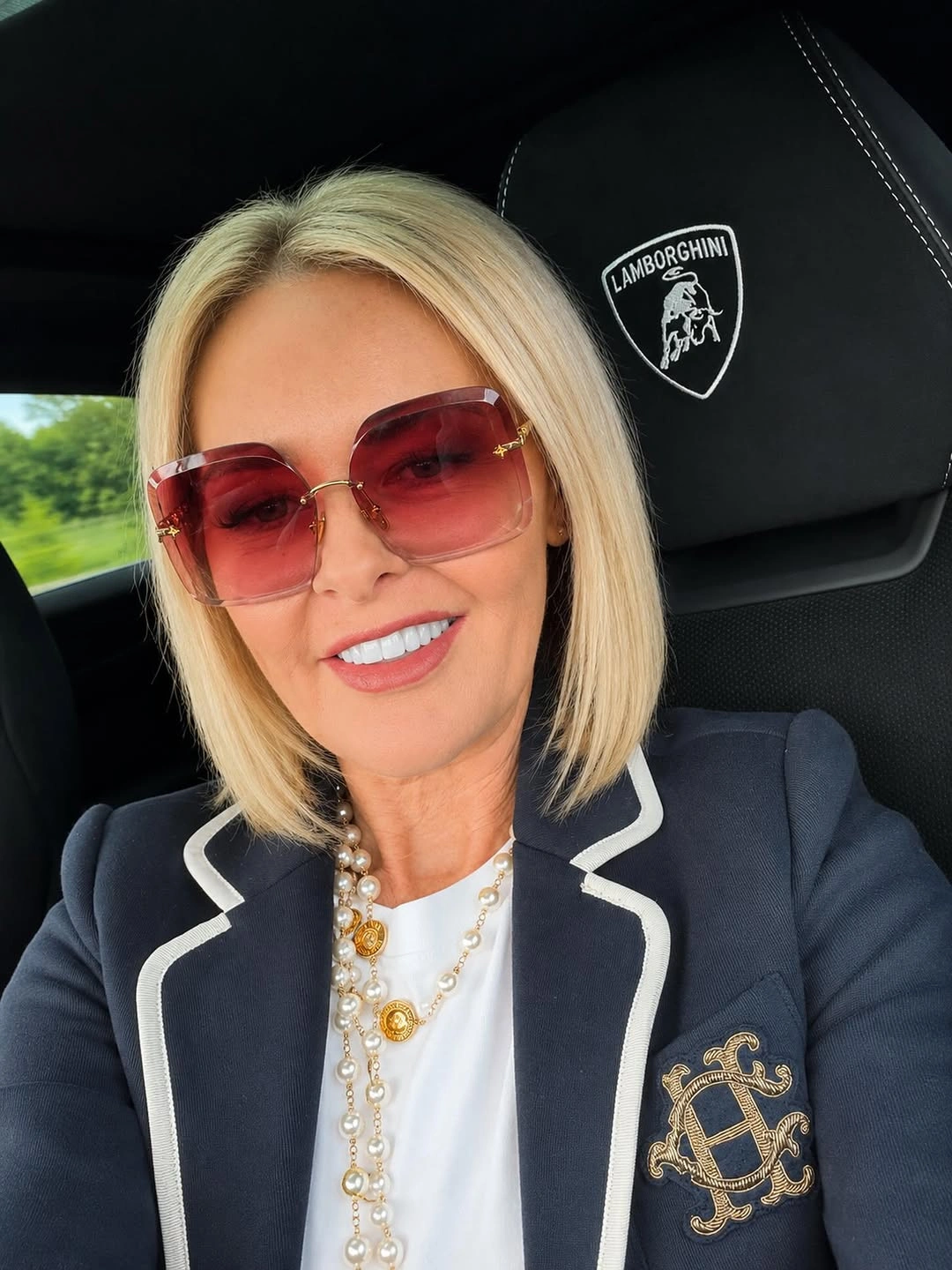 Straight blonde angled bob with center part and sunglasses